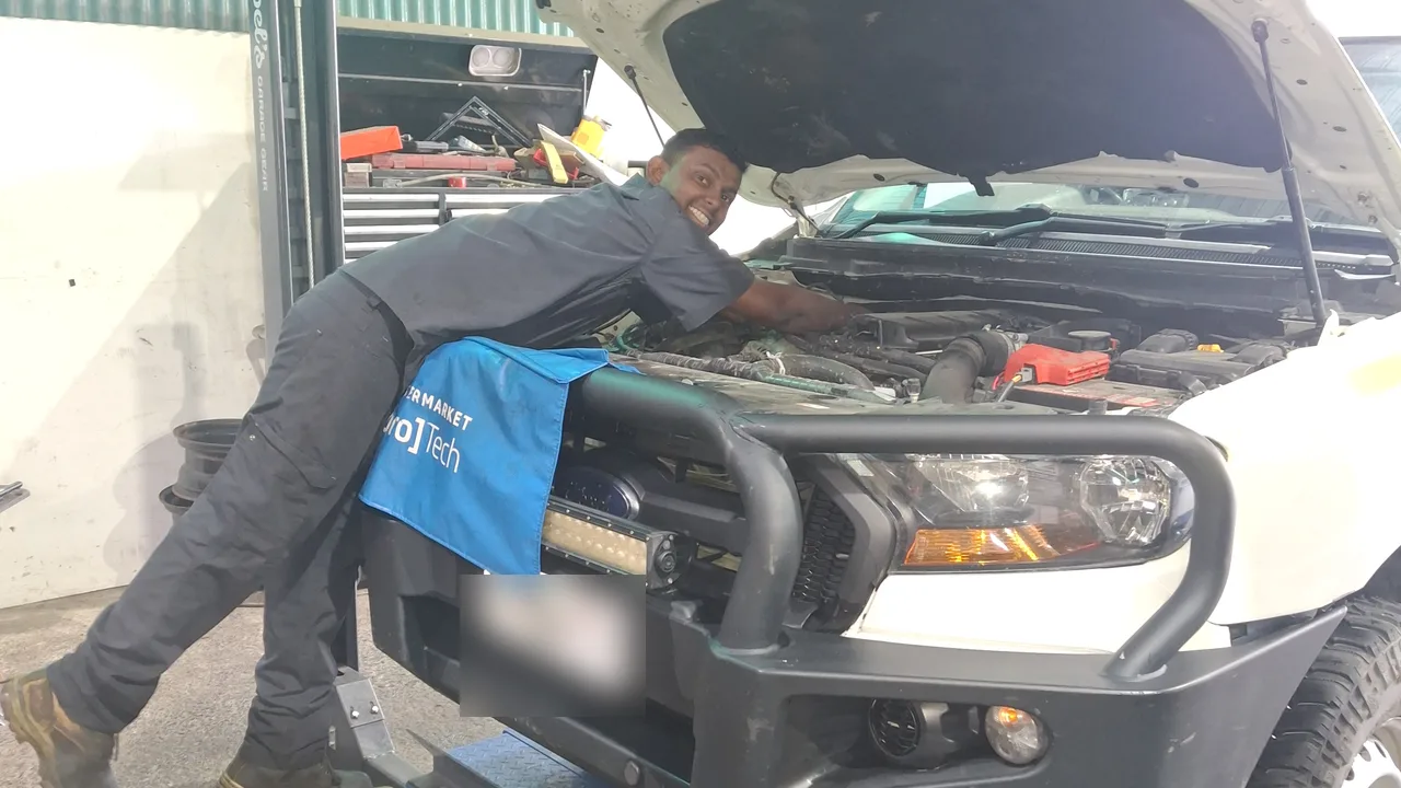 A Northside 4x4 technician working on a touring ute with a bull bar